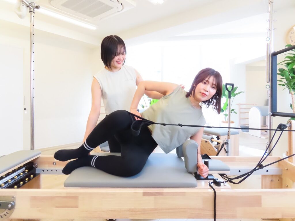 パーソナルピラティスのレッスンをする女性