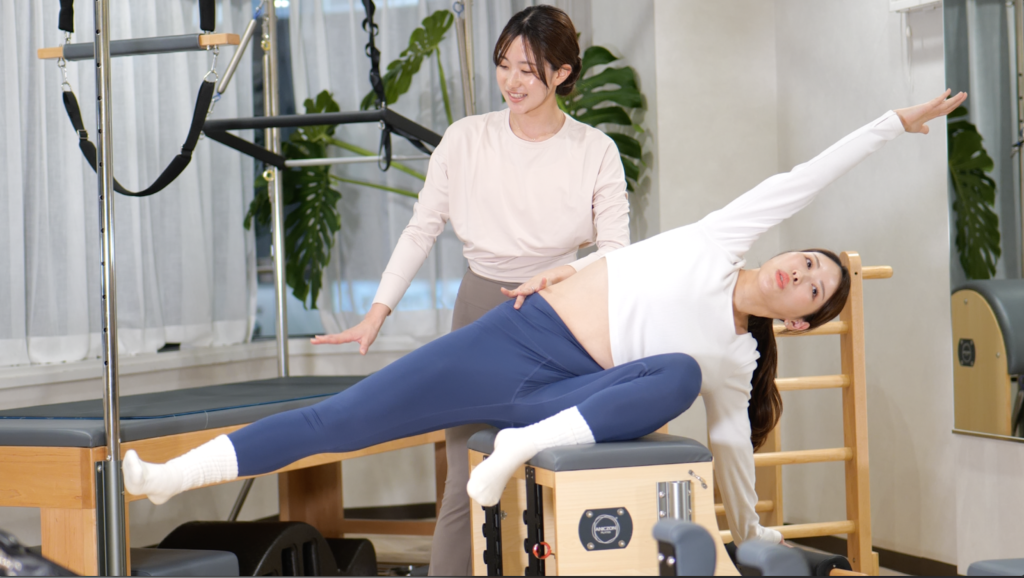 パーソナルピラティスレッスンを受ける女性